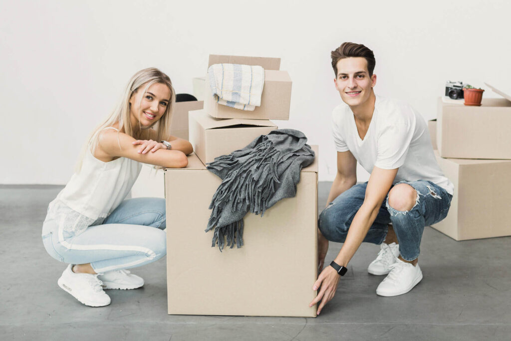a young couple moving boxes to a new home