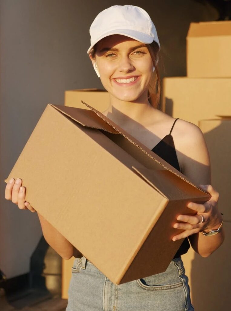 A girl smiling while loading boxes i the truck