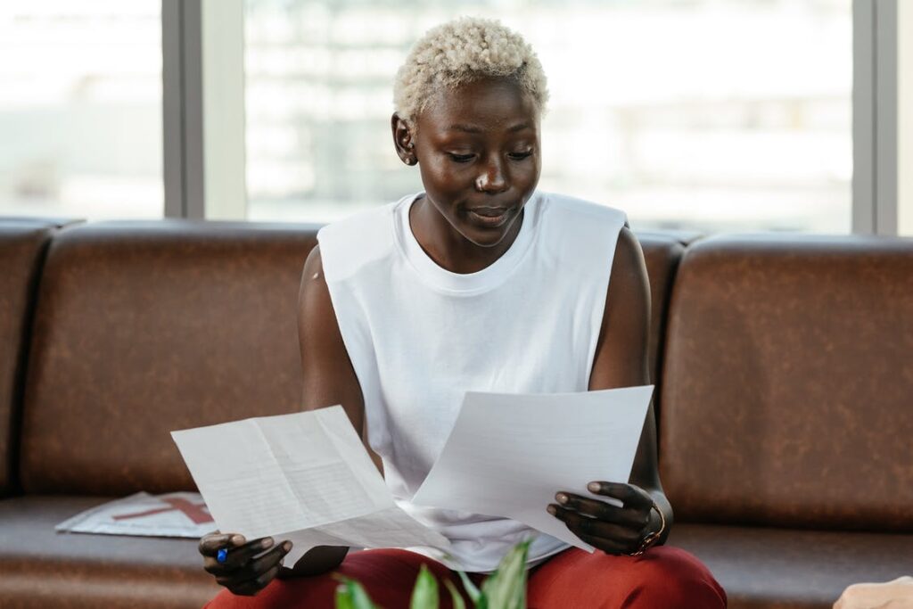 focused-black-woman-examining-documents-in-office