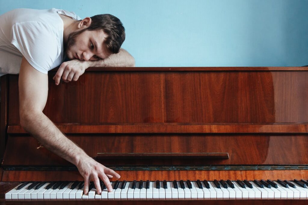 melancholic-pianist-playing-piano-near-blue-wall